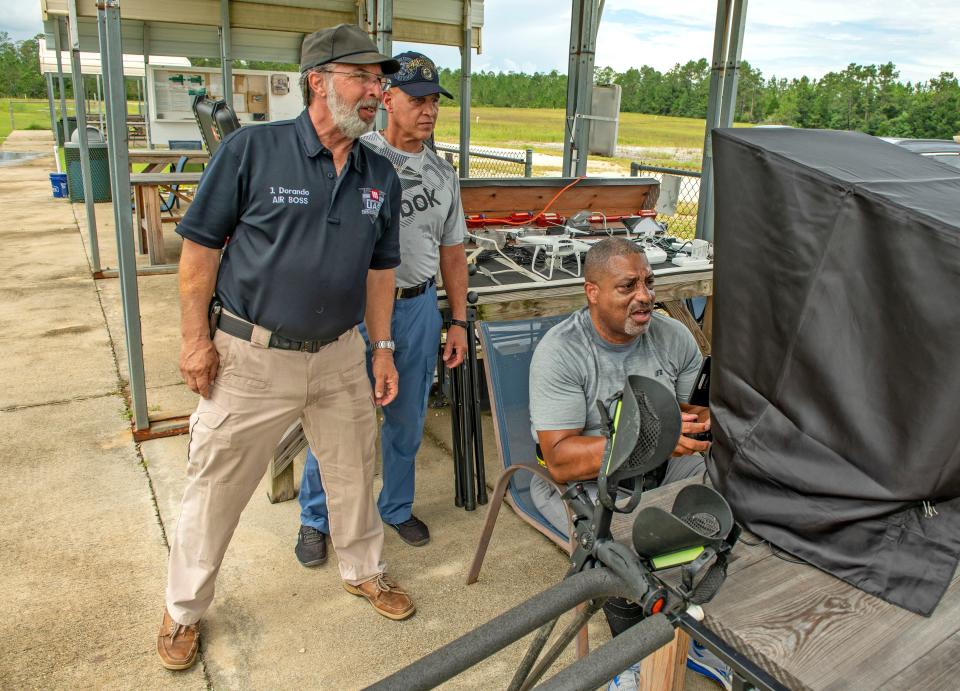 Drone instructor Joseph Dorando watches as student Terry Wallace takes flight Monday at the Escambia RC Model Park. Wallace is taking part in a Wounded Eagle UAS program that teaches wounded and disabled veterans how to operate and repair drones, as well as earn an FAA or commercial drone driver's license.