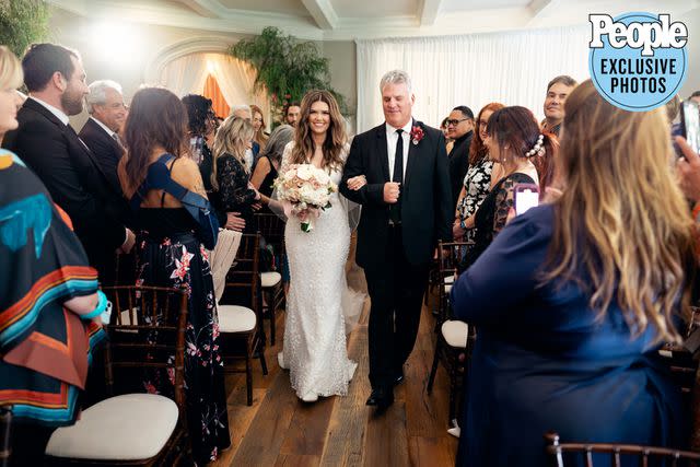 <p>Christine Skari Photography</p> Andraia Van Halen and her father, Michael Allsop, walking down the aisle together in the couples living room.