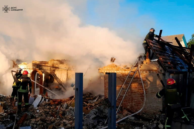 Photo diffusée par les services d'urgence ukrainiens, le 8 mai 2024, montrant des secours intervenant sur une maison détruite par une attaque de missile dans la région de Kiev (Handout)