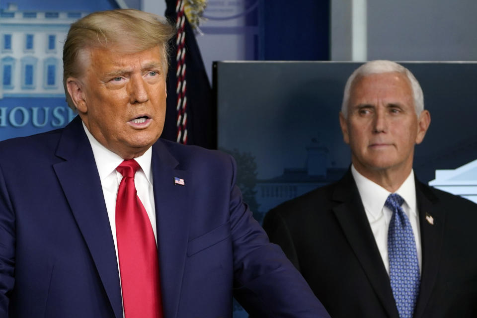 FILE - In this Nov. 24, 2020, file photo President Donald Trump speaks in the press briefing room as Vice President Mike Pence listens in Washington. (AP Photo/Susan Walsh, File)