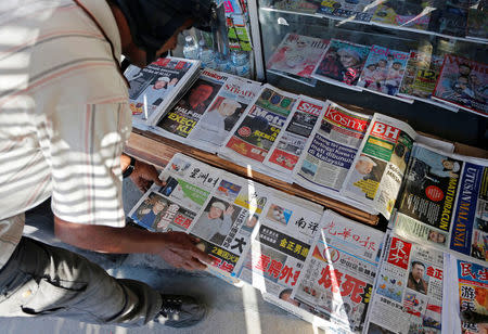 A newspaper vendor arranges newspapers showing front pages with images of Kim Jong Nam, at a news-stand outside Kuala Lumpur, Malaysia February 15, 2017. REUTERS/Lai Seng Sin