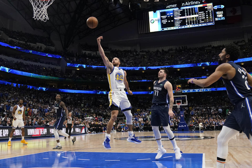 Golden State Warriors guard Stephen Curry (30) drives to the basket ahead of Dallas Mavericks guard Luka Doncic (77) during the second half of Game 3 of the NBA basketball playoffs Western Conference finals, Sunday, May 22, 2022, in Dallas. (AP Photo/Tony Gutierrez)