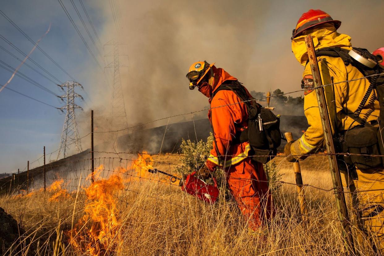 Firefighters set a back fire along a hillside near PG&E; power lines during firefighting operations to battle the Kincade Fire in Healdsburg, Calif. on Oct. 26, 2019.
