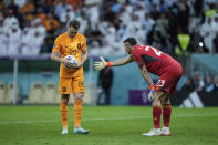 Argentina's goalkeeper Emiliano Martinez, right, asks the ball from Teun Koopmeiners of the Netherlands during the World Cup quarterfinal soccer match between the Netherlands and Argentina, at the Lusail Stadium in Lusail, Qatar, Saturday Dec. 10, 2022. (AP Photo/Jorge Saenz)