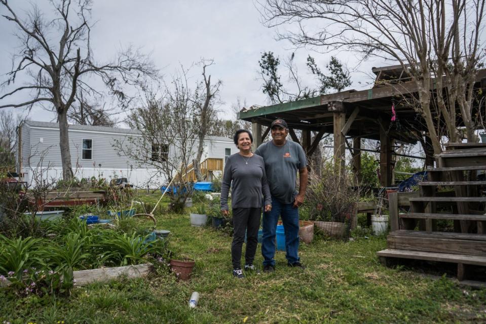 Brenda and Earl Billiot stand outside their hurricane-damaged home in Pointe-aux-Chenes and their FEMA trailer in March.