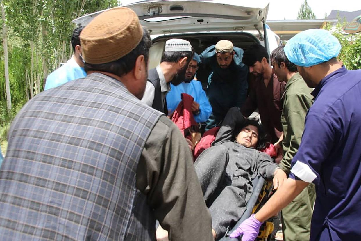 This photograph, taken on June 22, 2022, and received as a courtesy of the Afghan government-run Bakhtar News Agency, shows Afghan men moving an injured quake victim to a hospital following an earthquake in Gayan district, Paktika province. 