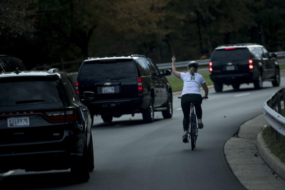 After leaving the White House to play golf, Donald Trump's motorcade was given the middle finger by a woman riding her bike.