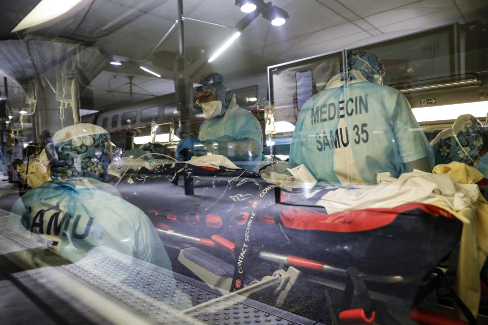 FILE - In this April 1, 2020 file photo, medical staff take care of a patient infected with the coronavirus in a train at the Gare d'Austerlitz train station in Paris. On high-speed trains fitted out like hospitals and military planes, France has moved hundreds of intensive care patients around the country in an exceptional effort to relieve congested hospitals and stay ahead of the fast-moving virus The new coronavirus causes mild or moderate symptoms for most people, but for some, especially older adults and people with existing health problems, it can cause more severe illness or death. (Thomas Samson, Pool via AP, File)