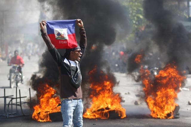 A demonstrator holds up a Haitian flag