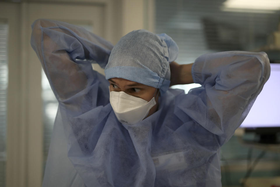 A nurse adjusts their suit in a COVID-19 area in a Marseille hospital, southern France, Thursday, Sept.10, 2020. As the Marseille region has become France's latest virus hotspot, hospitals are re-activating emergency measures in place when the pandemic first hit to ensure they're able to handle growing new cases. (AP Photo/Daniel Cole)