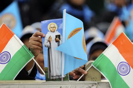 Nuns hold Indian flags and a picture of new Indian saint Kuriakose Elias Chavara before a canonisation ceremony led by Pope Francis, to make saints out of six men and women, in Saint Peter's square at the Vatican November 23, 2014. REUTERS/Alessandro Bianchi