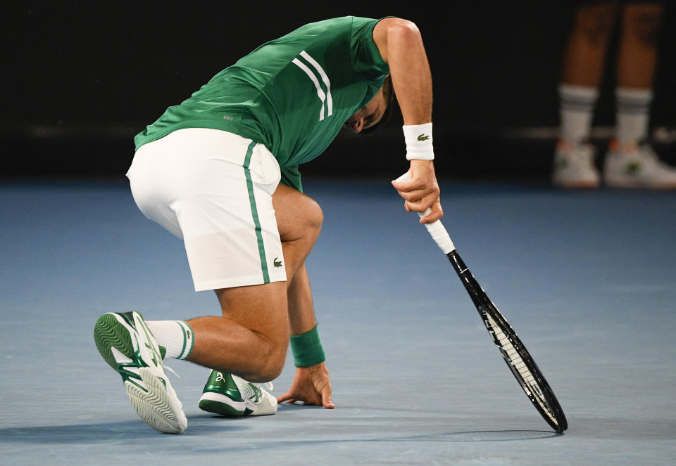 Serbia's Novak Djokovic stumbles during his third round match against United States' Talyor Fritz at the Australian Open tennis championship in Melbourne, Australia, Friday, Feb. 12, 2021.(AP Photo/Andy Brownbill)