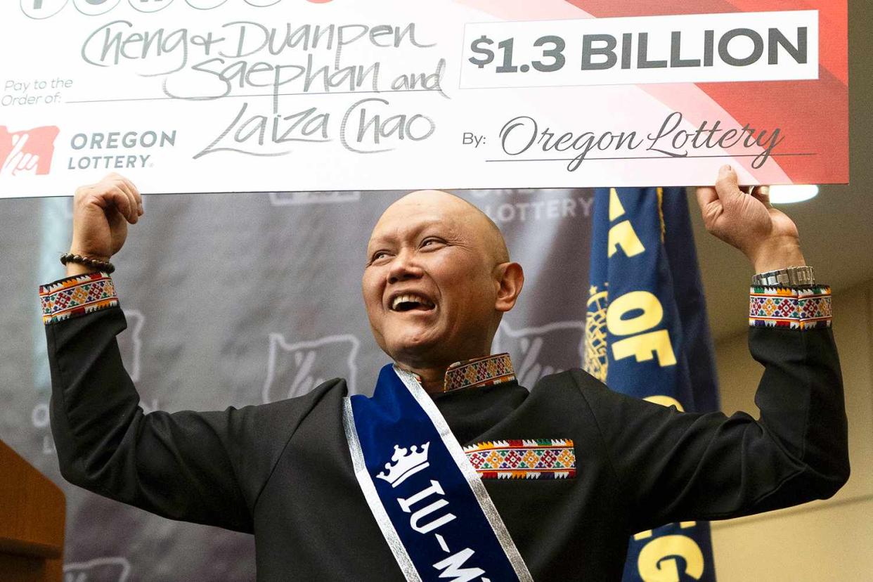 <p>AP Photo/Jenny Kane</p> Cheng "Charlie" Saephan holds display check above his head after speaking during a news conference where it was revealed that he was one of the winners of the $1.3 billion Powerball jackpot at the Oregon Lottery headquarters on April 29