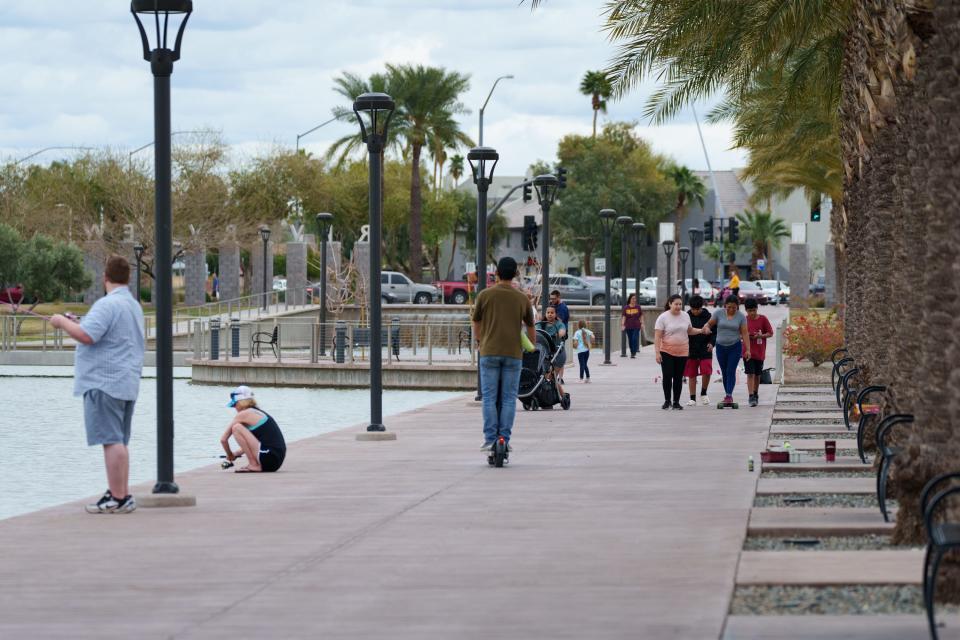 People walk along a path at Riverview Park on March 11, 2023, in Mesa.