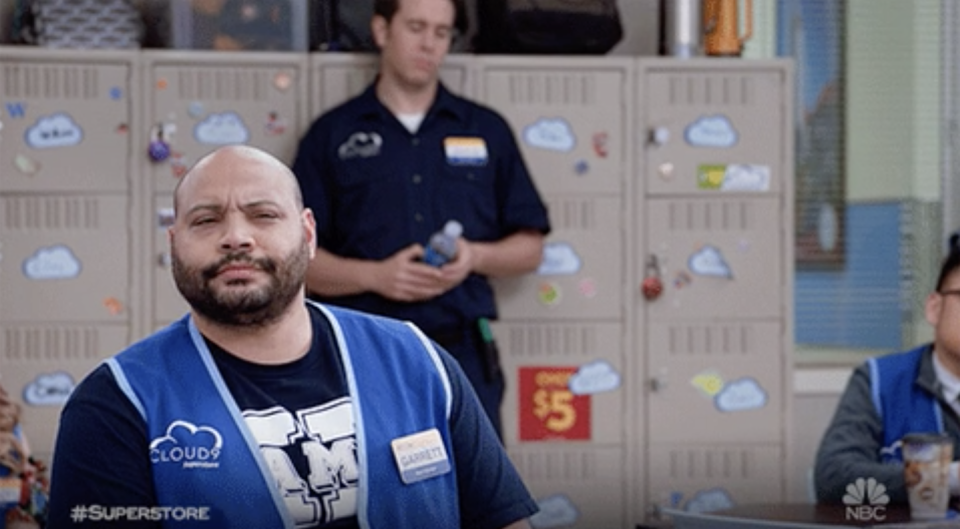 A man in a store vest looking confused