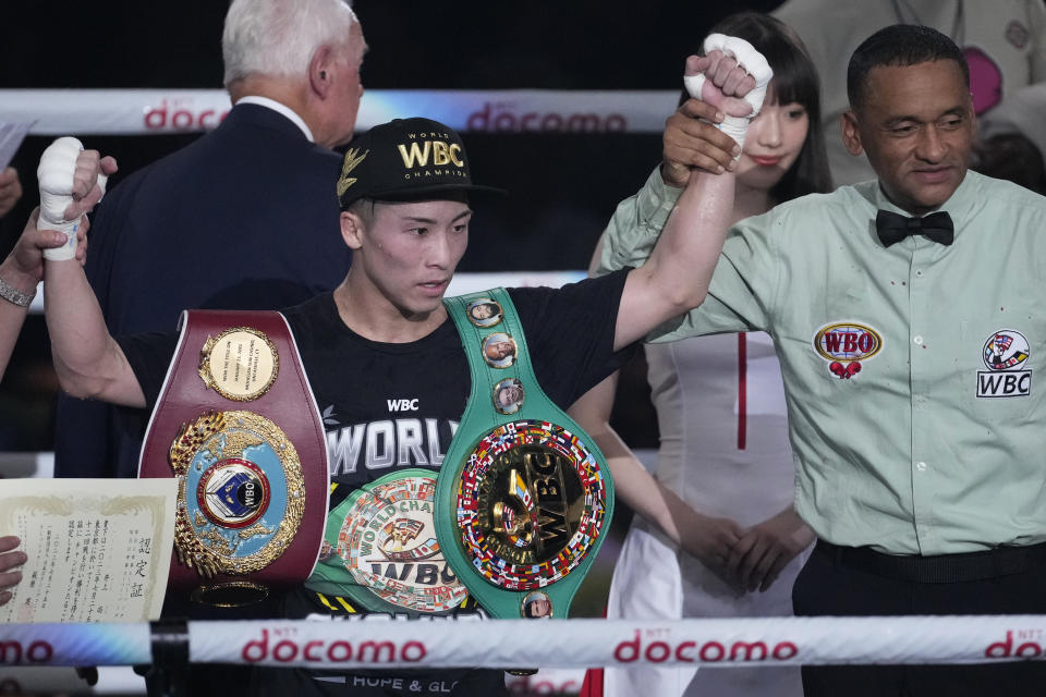 Naoya Inoue of Japan, left, celebrates after beating Stephen Fulton of the U.S. in the eighth round of a boxing match for the unified WBC and WBO super-bantamweight world titles in Tokyo, Tuesday, July 25, 2023. (AP Photo/Hiro Komae)