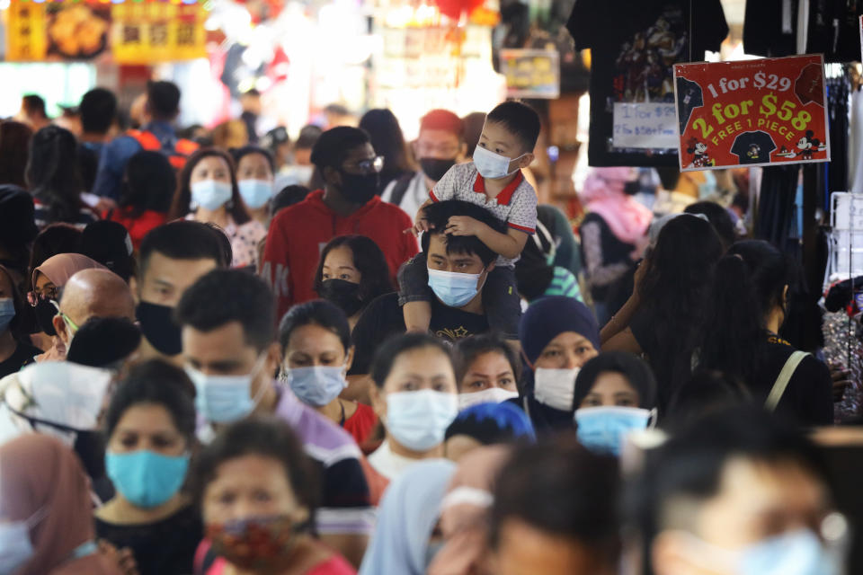 SINGAPORE - JANUARY 10: People wearing protective masks shop on January 10, 2021 in Singapore. As of January 10, the Ministry of Health confirmed 42 new imported COVID-19 cases, with zero cases in the wider community bringing the country's total to 58,907. (Photo by Suhaimi Abdullah/Getty Images)