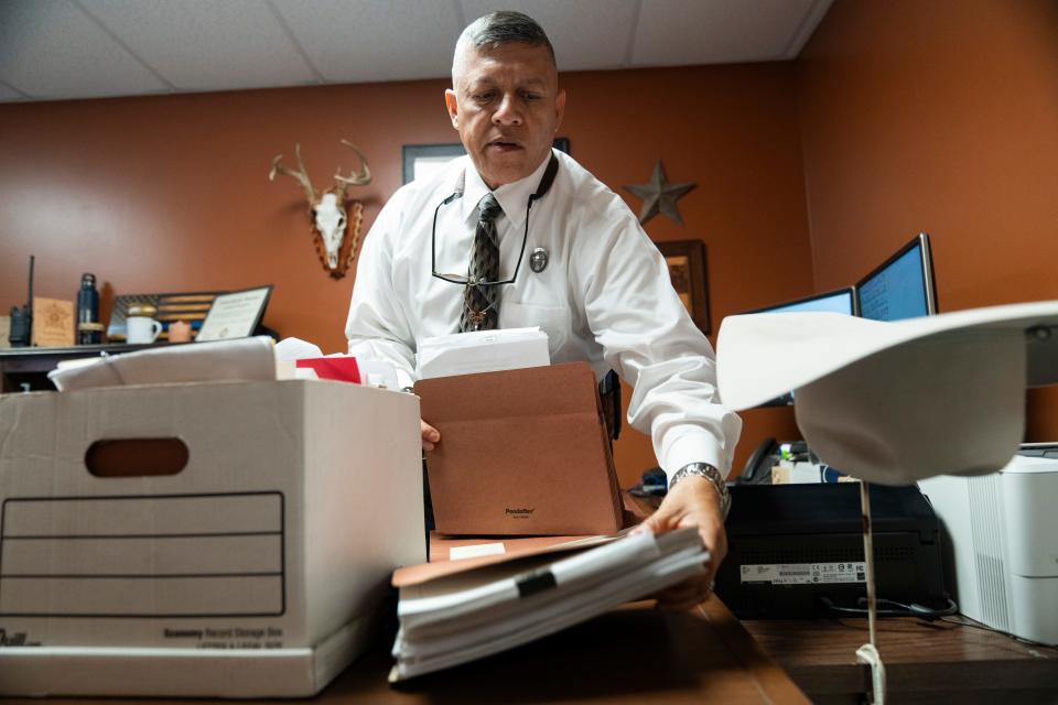 Texas Ranger E.J. Salinas organizes boxes of case files on his desk at the Zapata County Sheriff’s Office on May 28, 2024.