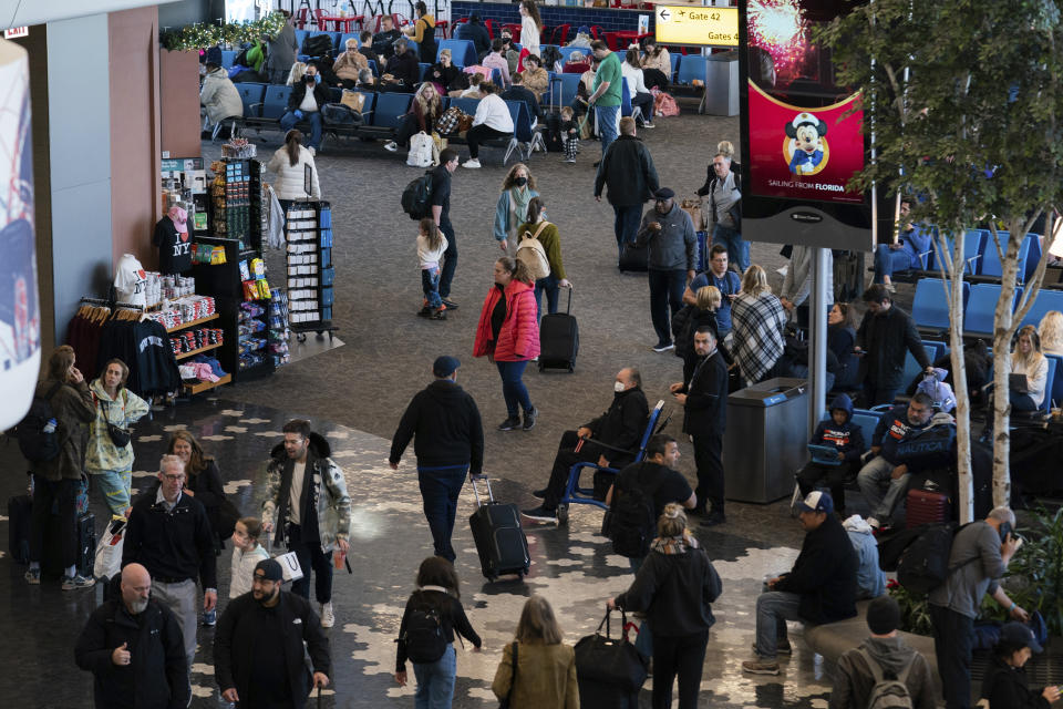 Travelers walk through LaGuardia Airport's Terminal B, Tuesday, Nov. 22, 2022, in New York. Travel experts say the ability of many people to work remotely is letting them take off early for Thanksgiving or return home later. Crowds are expected to rival those of 2019, the last Thanksgiving before the pandemic. (AP Photo/Julia Nikhinson)