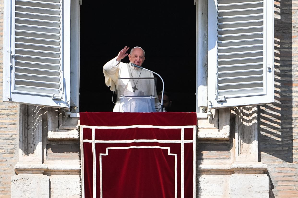 Pope Francis waves from a window.