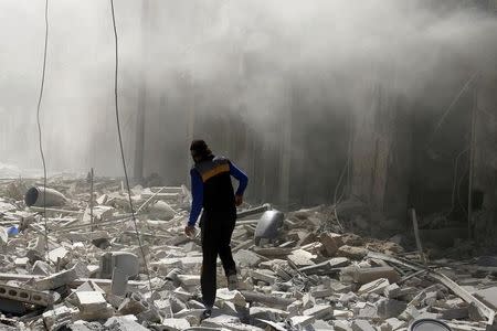 A man walks on the rubble of damaged buildings after an airstrike on the rebel held al-Qaterji neighbourhood of Aleppo, Syria September 25, 2016. REUTERS/Abdalrhman Ismail