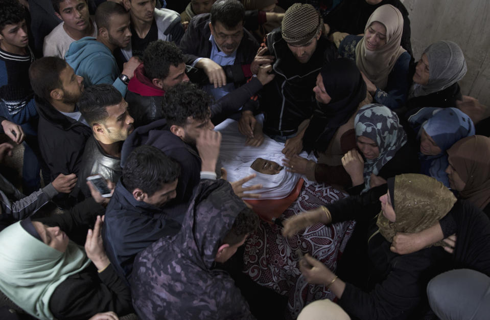 Relatives Mourn over the body of 21-year-old Palestinian, Mohammed Saad, at the family home during his funeral in Gaza City, Saturday, March 30, 2019. Gaza's Health Ministry says Saad was shot dead by Israeli forces near the fence with Israel, hours before an expected mass protest there. (AP Photo/Khalil Hamra)