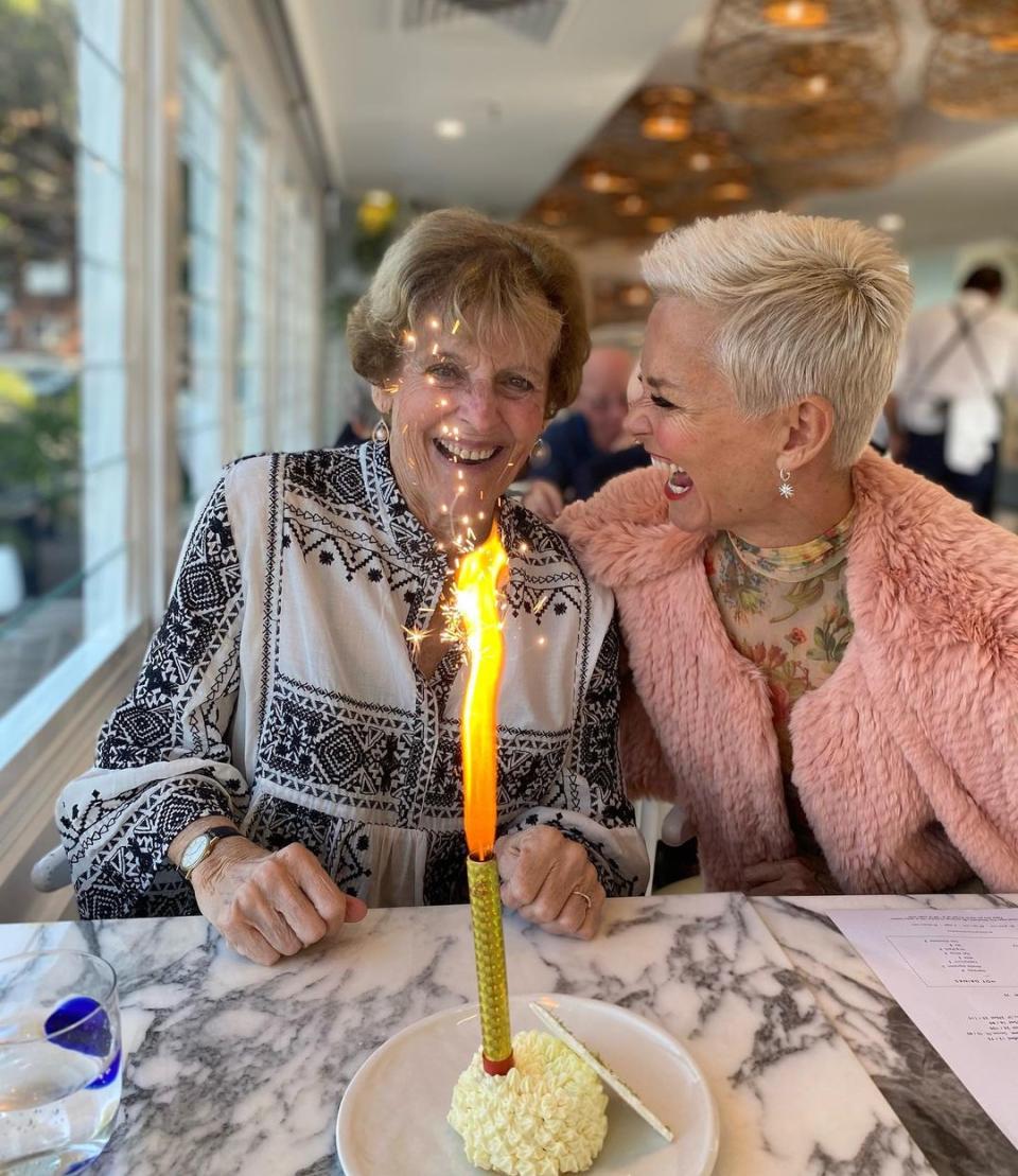 Jess Rowe with her mum, Penelope, celebrating a birthday at a restaurant with a cake.