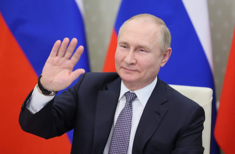 El presidente ruso Vladimir Putin saluda mientras asiste a la cumbre virtual "BRICS Plus" que reúne a los líderes de 17 países, entre ellos China, India, Brasil y Sudáfrica en la residencia estatal de Novo-Ogarevo, en las afueras de Moscú, el 24 de junio de 2022.