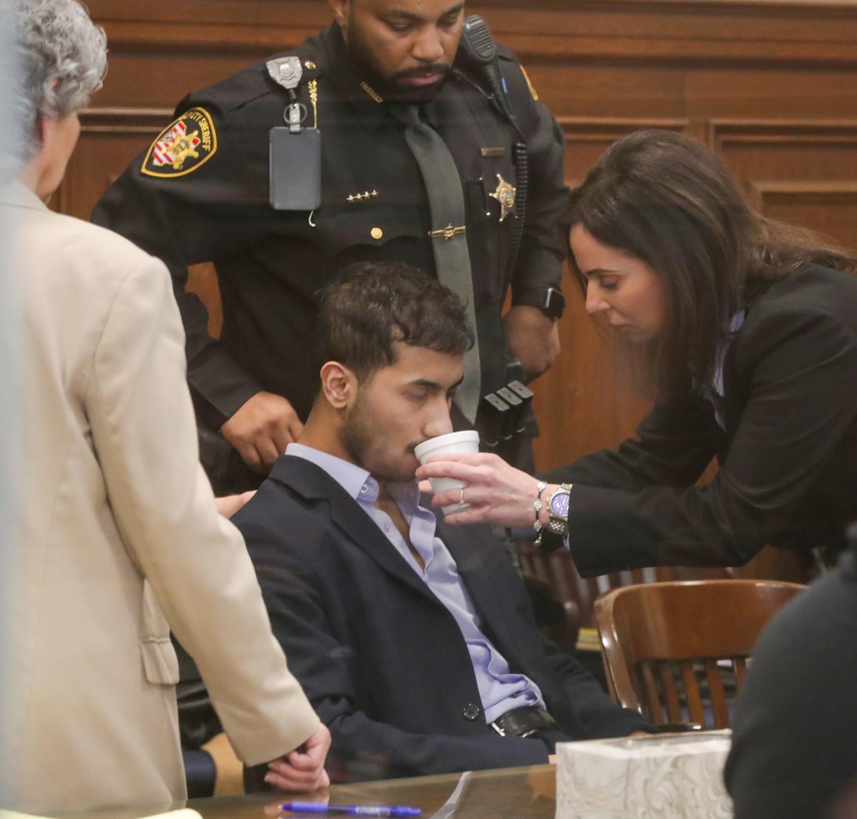 Mohamed Reeda is given a sip of water by defense attorney Linda Malek on Monday after falling ill while a verdict was read by Judge Kelly McLaughlin in Summit County Common Pleas Court. Reeda was found guilty on one count of rape, one count of attempted rape and three  counts of kidnapping by a jury.