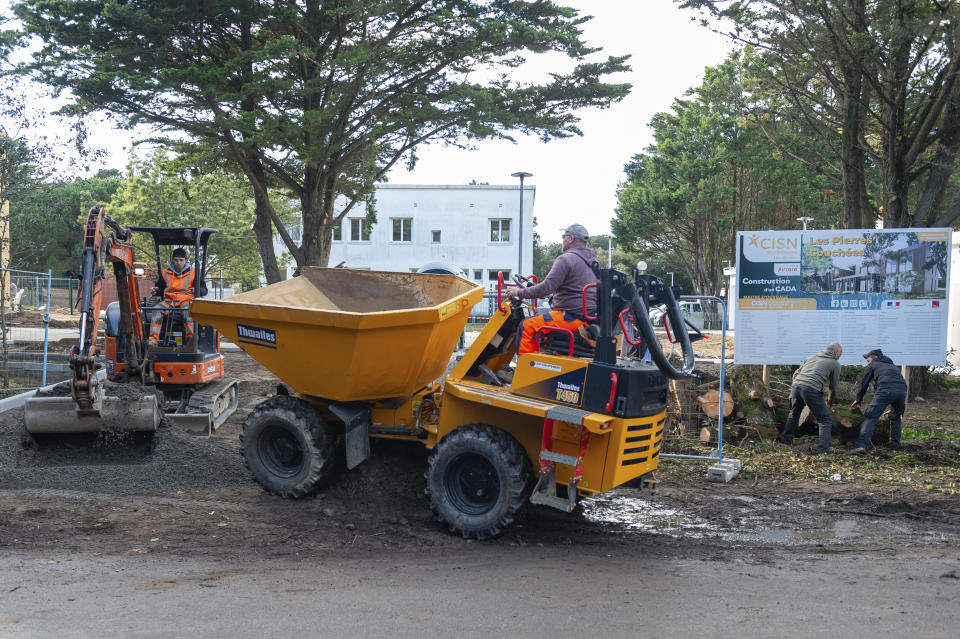 Workers operate at the main entrance of the future reception center for asylum seekers in Saint-Brevin-les-Pins, on Nov.28, 2023. A plan to house them near a school triggered protests that children would be at risk. (AP Photo/Mathieu Pattier)