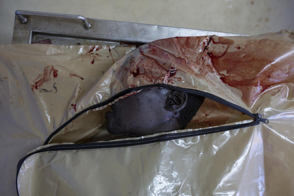 In this Thursday, Aug. 23, 2018 photo, an unidentified man lies in a body bag after forensic examination at a mortuary in the Hillbrow neighborhood of Johannesburg. (AP Photo/Bram Janssen)