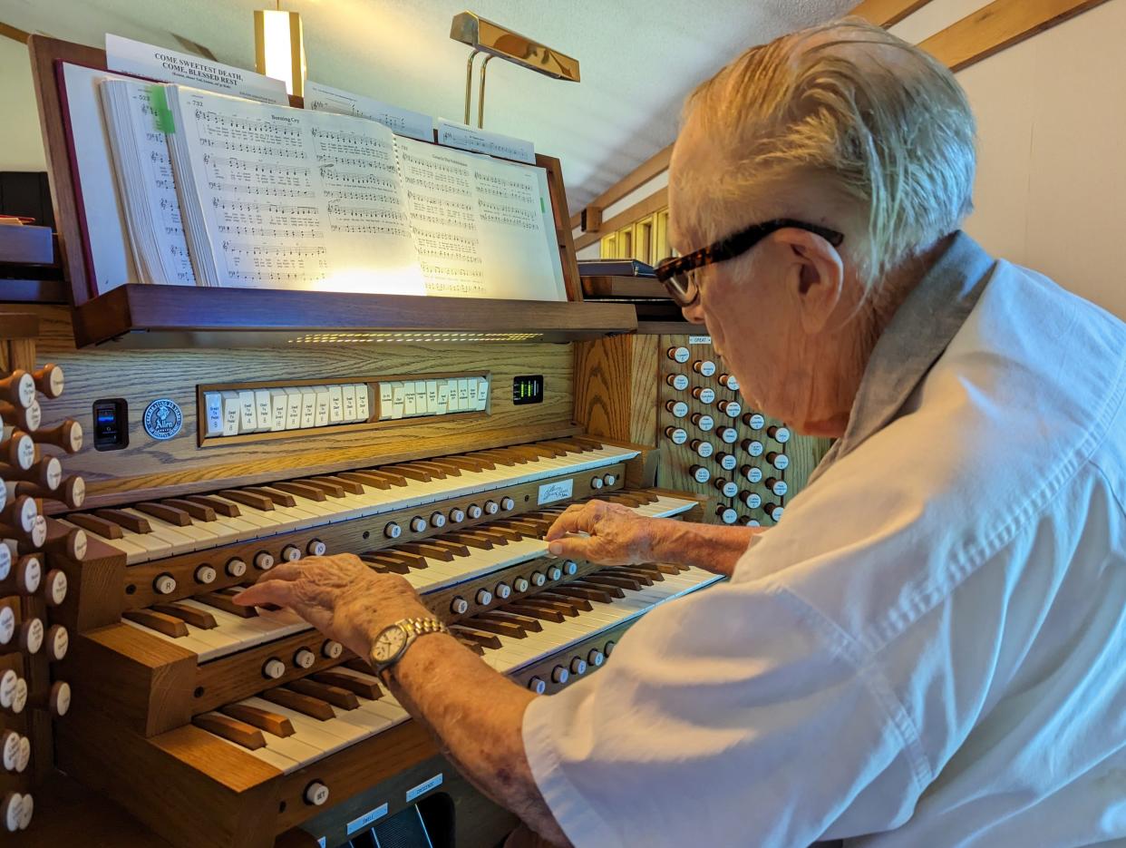 W. Robert Morrison plays a hymn on the Allen electric organ he recently donated to Holy Trinity Lutheran Church in Massillon in memory of his late wife. Morrison, 97, will headline a dedication concert at the church on Sept. 24.