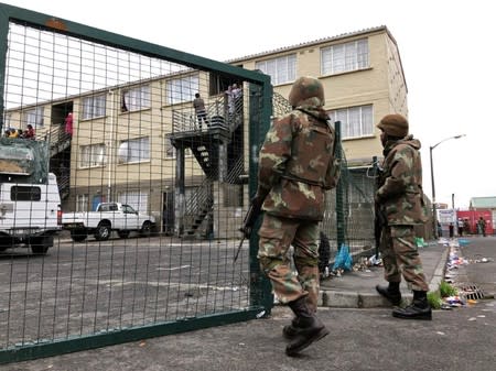 Soldiers patrol as they are deployed to quell gang violence in Manenberg township, Cape Town