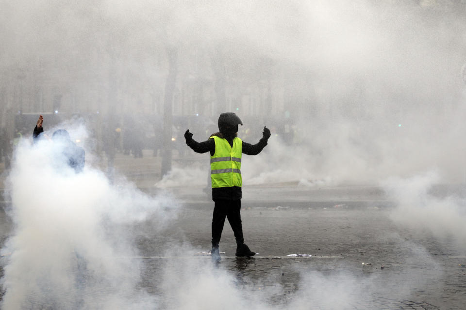 A yellow vest protester taunts riot police during clashes around the Arc of Triomphe in Paris, France, Saturday, Jan. 12, 2019. Authorities deployed 80,000 security forces nationwide for a ninth straight weekend of anti-government protests. (AP Photo/Kamil Zihnioglu)