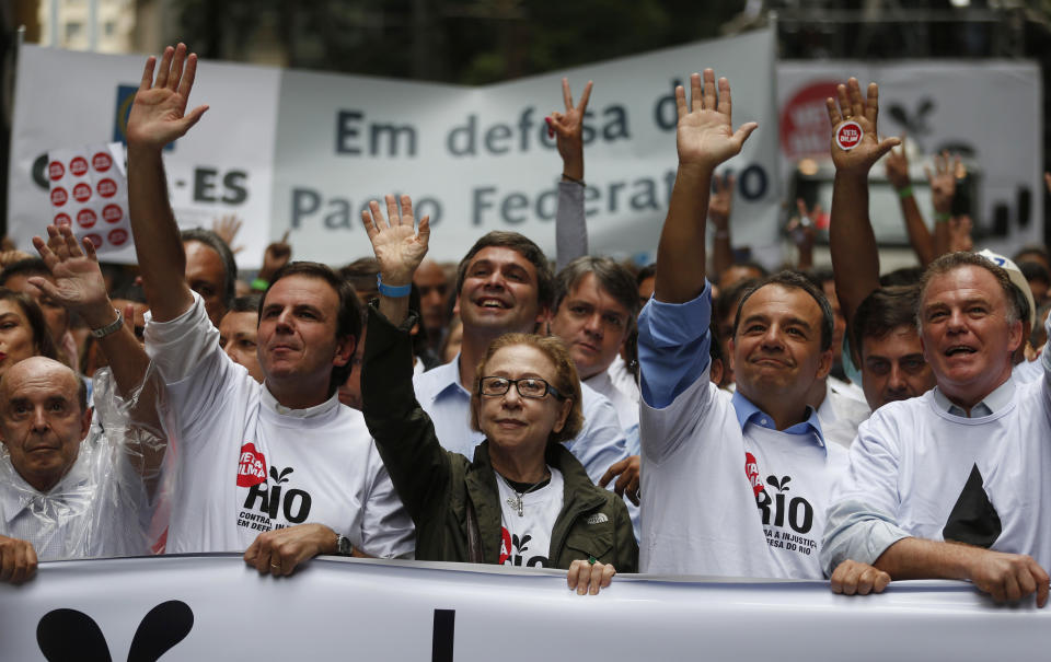 Rio de Janeiro's Governor Sergio Cabral, second from right, Brazilian actress Fernanda Montenegro, center, and Rio de Janeiro's Mayor Eduardo Paes, second from left, lead a march in Rio de Janeiro, Brazil, Monday, Nov. 26, 2012. Thousands of demonstrators gathered in downtown Rio de Janeiro for a march against legislation that officials here insist would strip this oil-producing state of much of its income from the energy sector. (AP Photo/Victor R. Caivano)