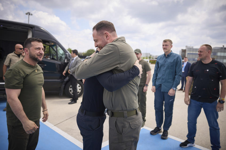 In this photo provided by the Ukrainian Presidential Press Office, Ukrainian President Volodymyr Zelenskyy, left, smiles as Head of the Presidential Office Andriy Yermak, centre, hugs with defender of the Azovstal steel plant Serhii Volynskyi at Istanbul international airport in Istanbul, Turkey, Saturday, July 8, 2023. Five commanders of the defence of the Azovstal steel plant, a gruelling months-long siege early in the war, were returning from Turkey on the plane with Zelenskyy. (Ukrainian Presidential Press Office via AP)