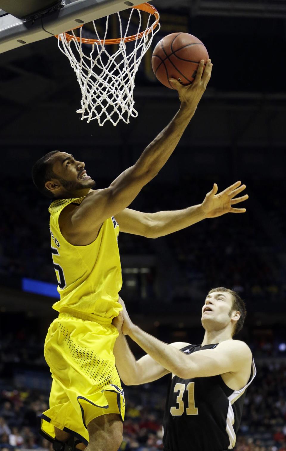 Michigan forward Jon Horford (15) goes to the basket over Wofford forward C.J. Neumann (31) during the first half of a second round NCAA college basketball tournament game Thursday, March 20, 2014, in Milwaukee. (AP Photo/Morry Gash)