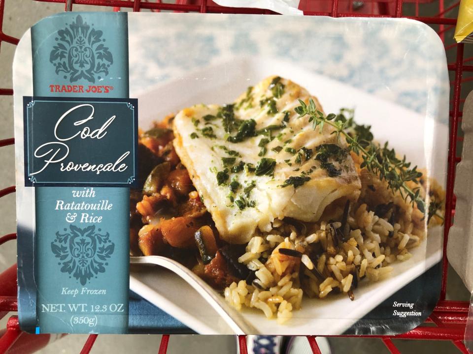 A package of Trader Joe's cod provencale with ratatouille and rice in a red shopping cart.