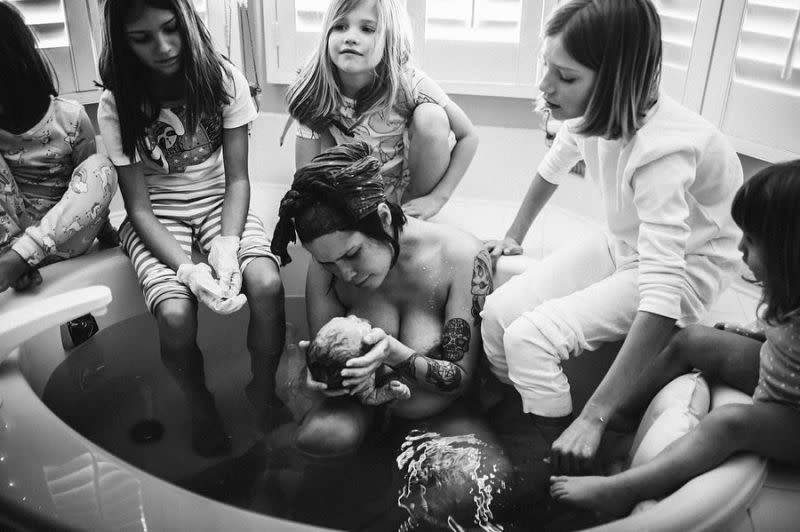 Les cinq filles autour de leur maman assise dans la baignoire avec sa sixième fille dans les bras. Photo: Rebecca Burt Photography