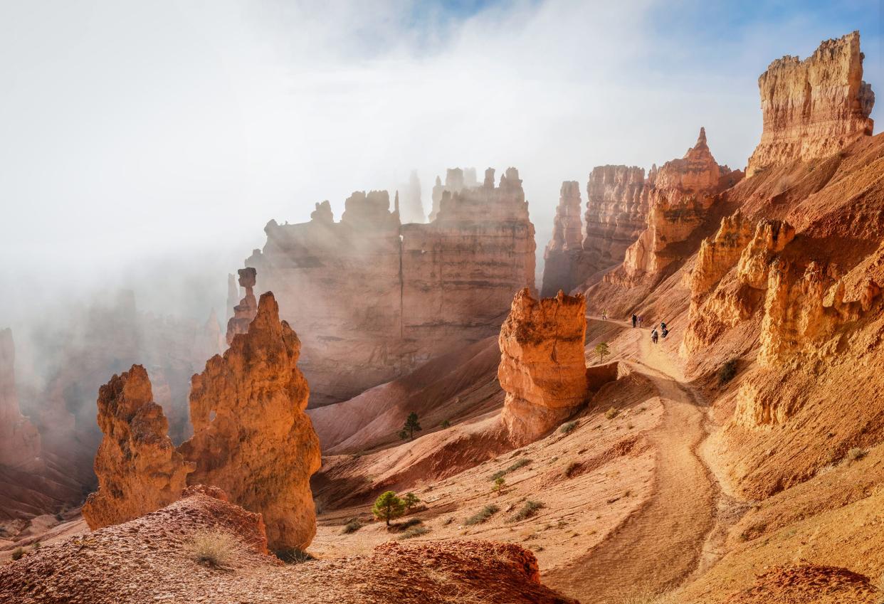 trekking Navajo loop trail Bryce Canyon National Park at sunrise with fog