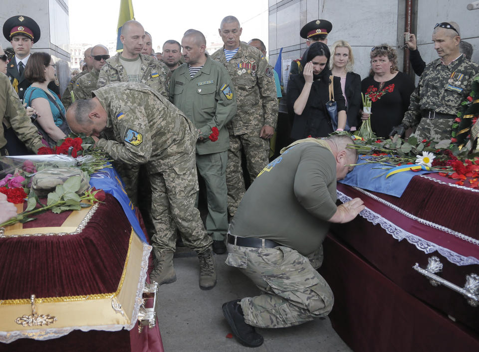 <p>Ukrainian soldiers pay the last tributes to the coffins bearing the bodies of Sergiy Baula and Mykola Kuliba, soldiers who were killed in the war conflict-hit Donetsk region, during a commemoration ceremony in Independence Square in Kiev, Ukraine, May. 26, 2016. (Efrem Lukatsky/AP) </p>