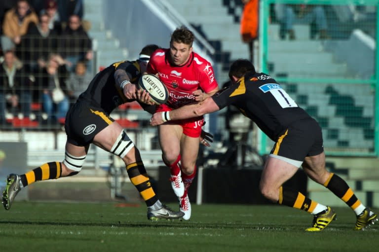 Toulon's winger Drew Mitchell (C) is tackled by Wasps' defenders during a European Champions Cup rugby union match on January 17, 2016 at the Mayol stadium in Toulon, southeastern France