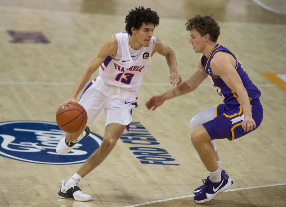 Evansville’s Blaise Beauchamp (13) drives against Northern Iowa's Bowen Born (13) as the University of Evansville Purple Aces take on the University of Northern Iowa Panthers at Ford Center in Evansville, Ind., Wednesday evening, Jan. 26, 2022. 