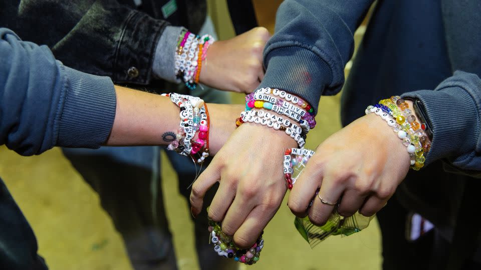Fans exchange friendship bracelets ahead of the opening night theatrical release of "Taylor Swift: The Eras Tour" concert movie. - Natasha Moustache/Getty Images