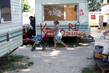 A woman walks past pre-fabricated homes seized by Police in an official Roma camp in Rome, Italy June 27, 2018. Picture taken June 27, 2018. REUTERS/Tony Gentile