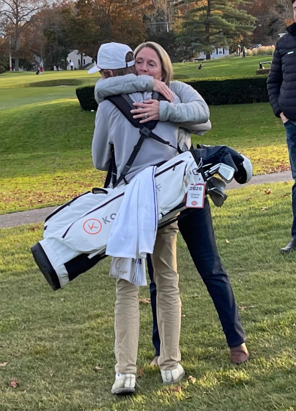 Dover-Sherborn's Charlie Potter receives a hug from his mother, Kate, after he completed his round as the individual state Division 2 champion at Thorny Lea on Oct. 31, 2023.