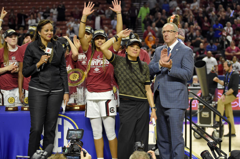 South Carolina head coach Dawn Staley, center right, and Tyasha Harris, center left, acknowledge the crowd after defeating Mississippi State in a championship match at the Southeastern Conference women's NCAA college basketball tournament in Greenville, S.C., Sunday, March 8, 2020. (AP Photo/Richard Shiro)