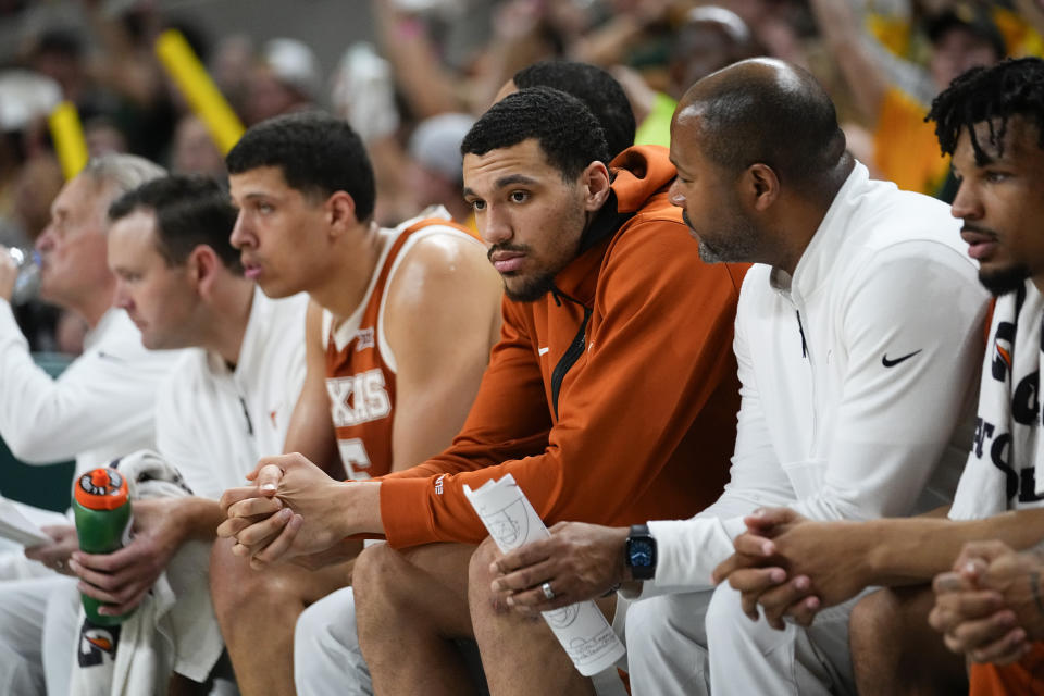 Texas's Dylan Disu, center, sits on the bench after suffering an injury during the second half of an NCAA college basketball game against Baylor, Monday, March 4, 2024, in Waco, Texas. Baylor won 93-85. (AP Photo/Julio Cortez)