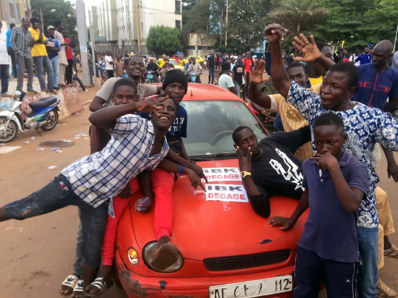 Opposition supporters react to the news of possible military mutiny, at Independence Square in Bamako