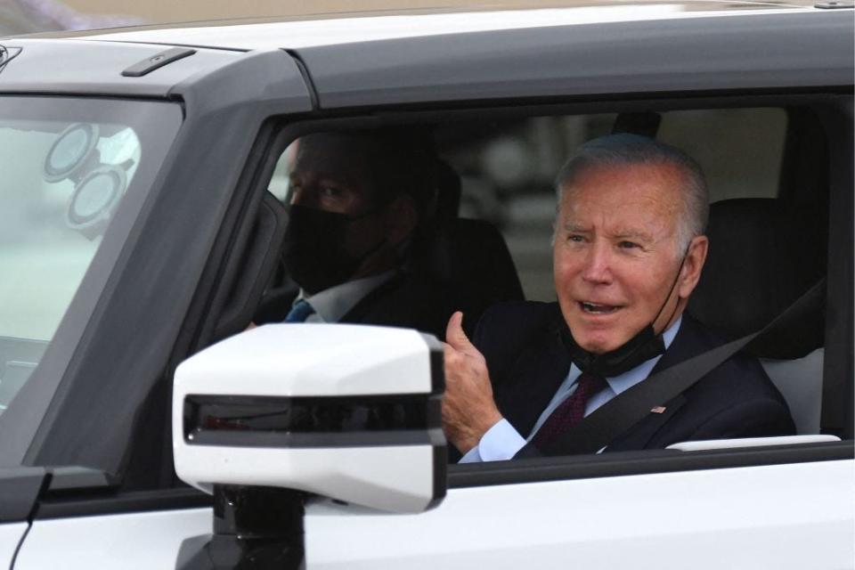 Joe Biden giving hte thumbs up while driving a white car